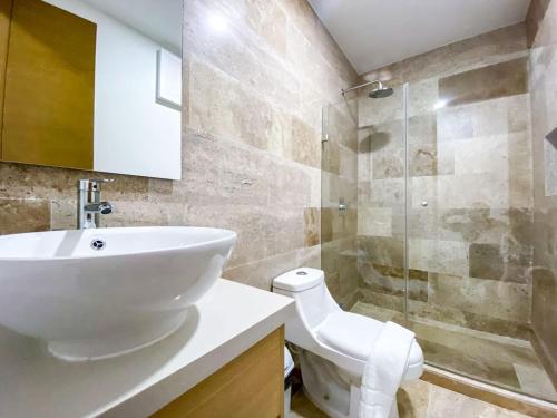 a bathroom with a sink and a toilet and a shower at Downtown Playa Studio with Rooftop Pool Steps to Everything in Playa del Carmen