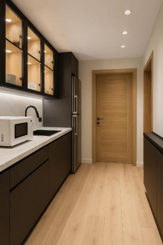 a kitchen with black cabinets and a white microwave at Luxury house in SODIC Villette with jacuzzi in Cairo