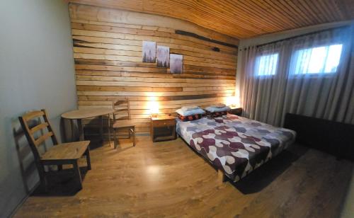 a bedroom with a bed and a wooden wall at Viitna Puhkekeskus in Viitna