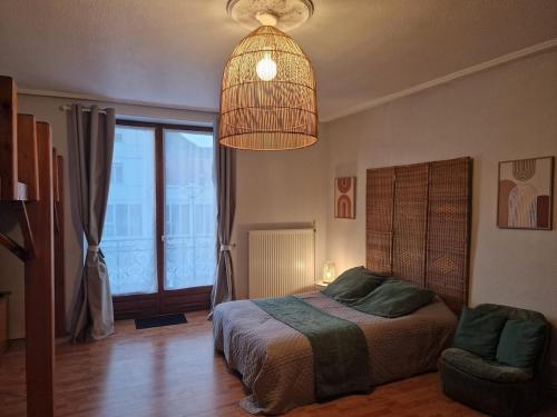 a bedroom with a bed and a pendant light at Studio 17, logement tout confort in Senones