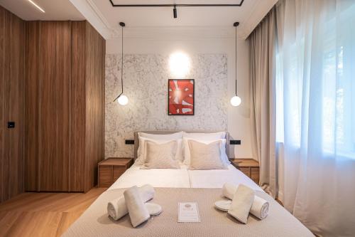 a bedroom with a large white bed with two pillows at Estium Luxury Rooms in Zadar