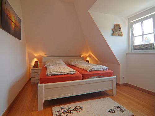 a small bedroom with a bed in a attic at Ferienhaus Weiße Düne, Zinnowitz in Zinnowitz