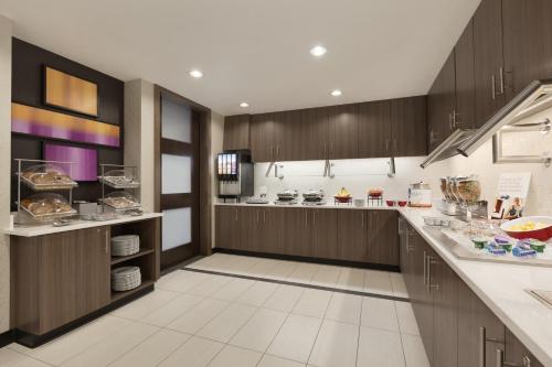 eine große Küche mit Holzschränken und weißen Fliesenböden in der Unterkunft Residence Inn San Angelo in San Angelo