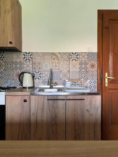 a kitchen with a sink and tiles on the wall at Pod Ogrodami in Stary Sącz