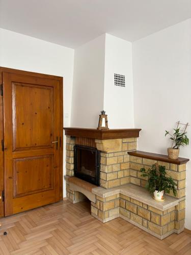 a room with a brick fireplace and a wooden door at Pod Ogrodami in Stary Sącz