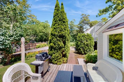 a patio with two chairs and a grill on a porch at Brewster Getaway in Brewster
