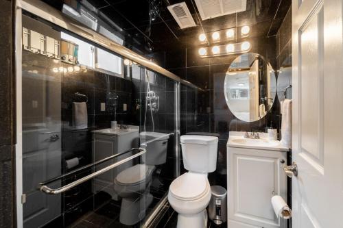 a bathroom with a toilet and a sink and a mirror at Renovated 4BR Escape Luxe Comfort and Hot Tub in Westminster