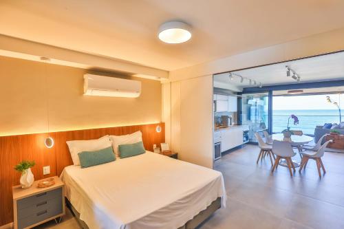 リオデジャネイロにあるPraia de Copacabana exclusive loft Bait Atlanticaのベッドルーム1室(ベッド1台付)、キッチン、テーブルが備わります。