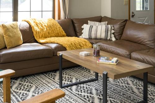 a living room with a brown couch and a coffee table at St Marys Glacier Retreat A Cozy Lakeside Escape in Idaho Springs