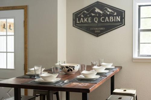 a wooden table with bowls and plates on it at St Marys Glacier Retreat A Cozy Lakeside Escape in Idaho Springs