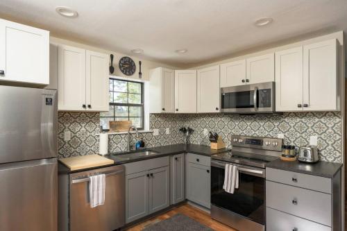 a kitchen with white cabinets and stainless steel appliances at St Marys Glacier Retreat A Cozy Lakeside Escape in Idaho Springs