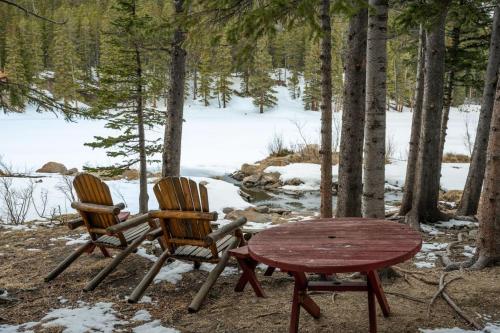 two chairs and a wooden table and a table and a table and a table at St Marys Glacier Retreat A Cozy Lakeside Escape in Idaho Springs