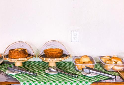 een tafel met drie schalen brood en gebak bij Santa Areia Lençóis Pousada in Santo Amaro