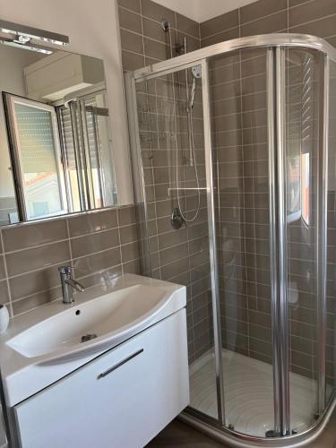 a bathroom with a shower and a sink and a mirror at Residenza Torricelli in Riccione