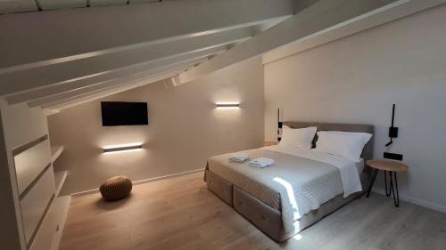 a bedroom with a bed and a tv on the wall at John&Nansy Cozy Apartment 1 in Plomarion