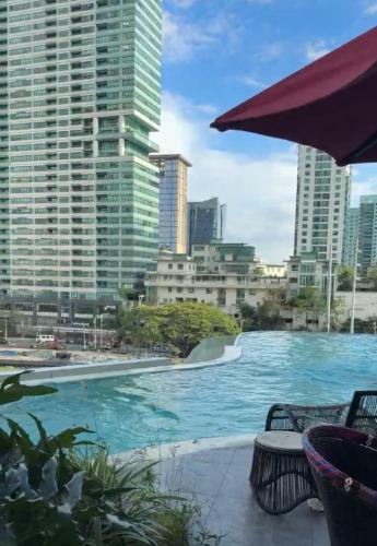 a swimming pool in a city with tall buildings at Novotel Suites Celestia at Hotel Residences Manila in Manila