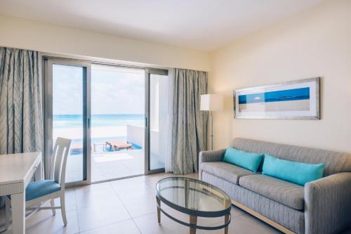 a living room with a couch and a glass table at Iberostar Selection Cancun - All Inclusive in Cancún
