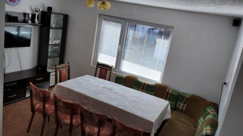 a dining room with a table and chairs and two windows at Елиани in Gabrovo