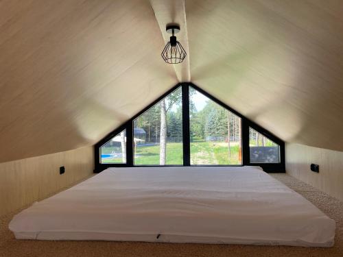 ein Schlafzimmer mit einem großen Bett mit einem großen Fenster in der Unterkunft EkoRelax & Fun Resort in Dobków