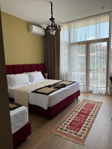 a bedroom with two beds and a large window at Villa Castriota in Krujë