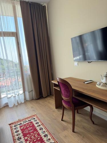 a room with a desk and a chair and a television at Villa Castriota in Krujë