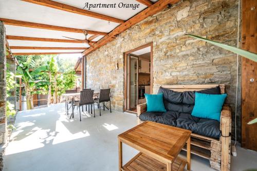 a stone walled patio with a couch and a table at Istrska kamnita hiša z velikim vrtom - Istrian Stone House with Big Garden in Marezige