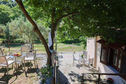 a patio with a table and chairs under a tree at F & B Collection - Skiathos for 2 in Skiathos Town