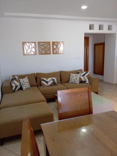 a living room with a couch and a table at Bungalow au bord de la mer in Kelibia