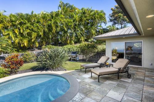 a patio with two chairs and a swimming pool at Hale Aikane in Kailua-Kona