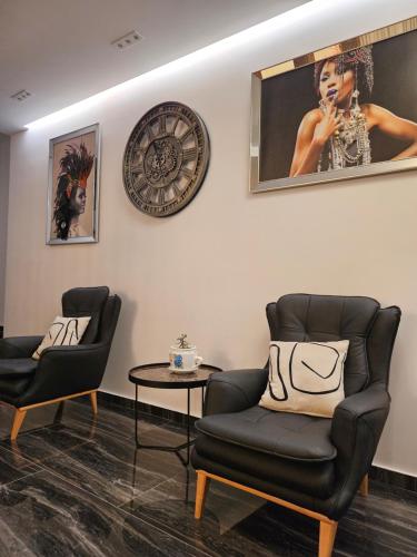 a waiting room with two chairs and a clock on the wall at 4 Stinët in Valbonë