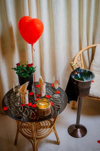 a table with a heart balloon and wine glasses at Cossara luxury villas - Adults Only in Balchik
