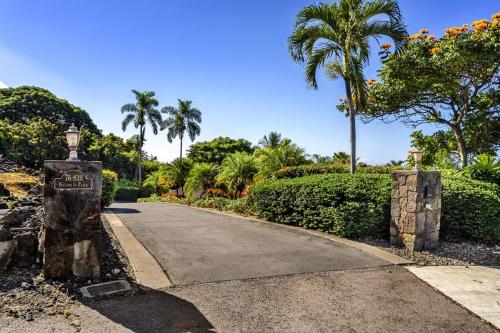a driveway with palm trees and a street sign at Hale Aikane in Kailua-Kona