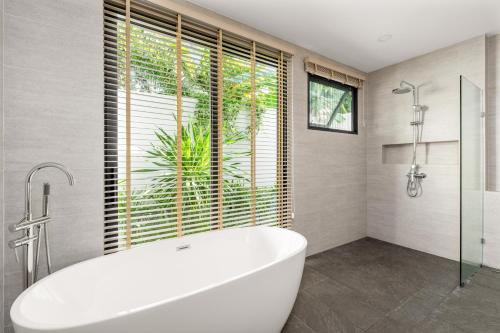 a bathroom with a tub and a large window at Samudo 3br Tropical Haven in Bophut