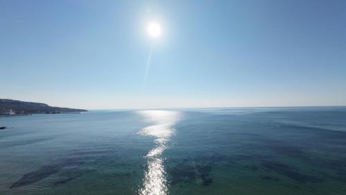 a view of the ocean with the sun reflecting on the water at Cossara luxury villas - Adults Only in Balchik