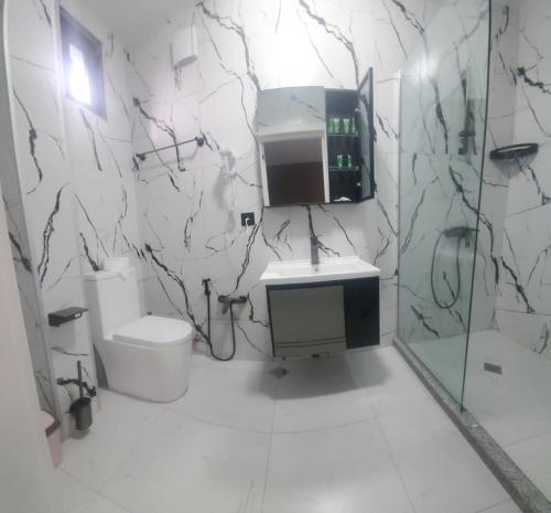 a white bathroom with a sink and a toilet at Elite Hotel Kobuleti in K'obulet'i
