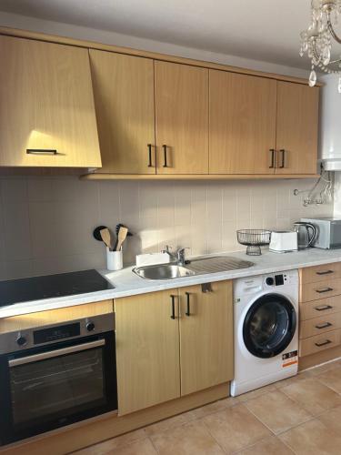 a kitchen with a sink and a washing machine at Luz Paradise in Luz