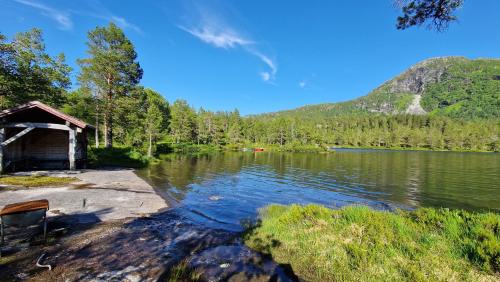 a view of a lake with a cabin next to it at Hov Hyttegrend in Viksdalen