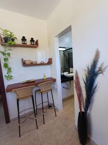a dining room with a table and two stools at Casa Praia - Recanto Tucuns Beira-Mar in Búzios