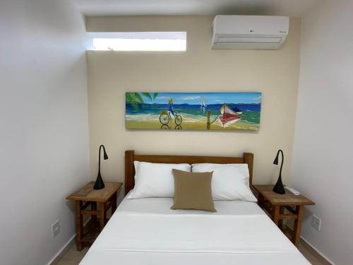 a bedroom with a white bed with two night stands at Casa Praia - Recanto Tucuns Beira-Mar in Búzios