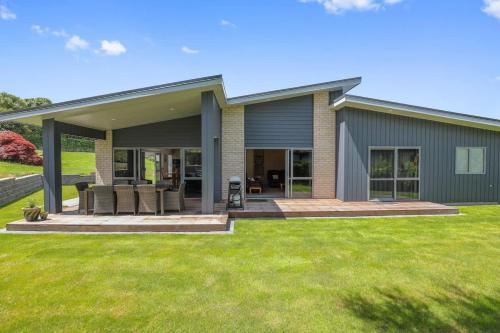 a house with a patio and grass at All Inn in Rotorua