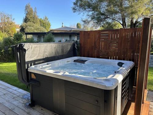a hot tub on a deck in a backyard at All Inn in Rotorua