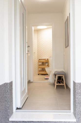 a hallway with a bathroom with a toilet and a stool at Pupi Studio Apartment Trogir in Trogir