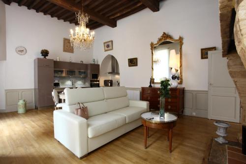 a living room with a white couch and a mirror at Le Royere in Sarlat-la-Canéda