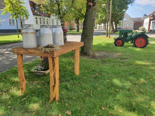 a table with buckets on top of it with a tractor at Schlafstall Eichholz in Kermen