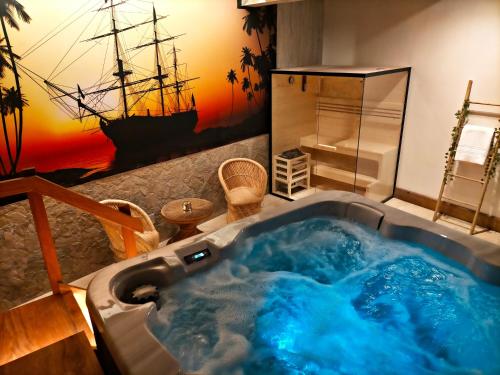 a jacuzzi tub in a bathroom with a ship mural at Casona De La Pinta in Ríocorvo