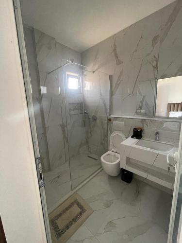 a bathroom with a shower and a toilet and a sink at Seliano Residence in Velipojë