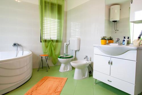 a bathroom with a tub and a sink and a toilet at Apartman Orbanići in Orbanići