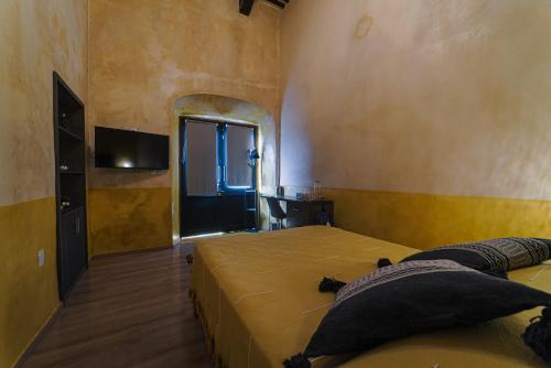 a bedroom with two beds and a flat screen tv at Hotel Boutique Casa Lanz XVII in Campeche