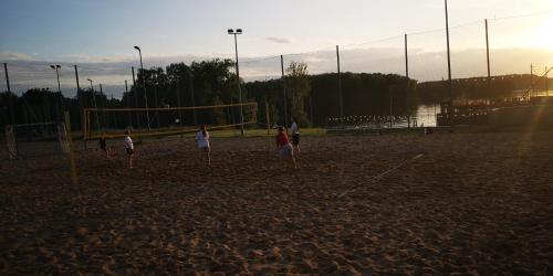 a group of people playing soccer on a beach at Omega Lake Apartments in Olsztyn