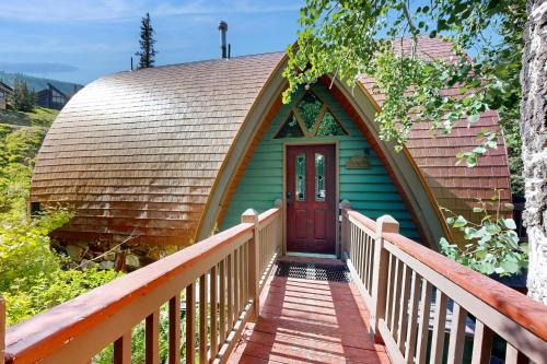 a green house with a brown roof and a wooden porch at Creekside Chalet in Alta